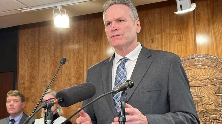 Alaska Gov. Mike Dunleavy holds during a news conference on...