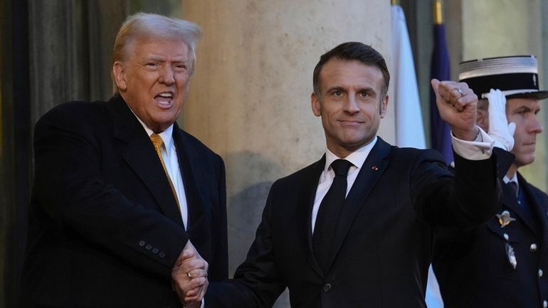 French President Emmanuel Macron welcomes President-elect Donald Trump as he...