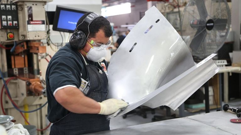 A welder works on an aircraft component at Air Industries...