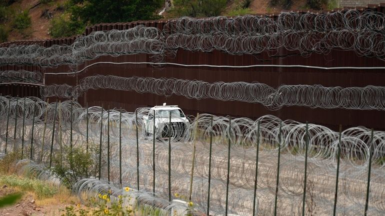 FILE - A vehicle drives along the U.S. side of...