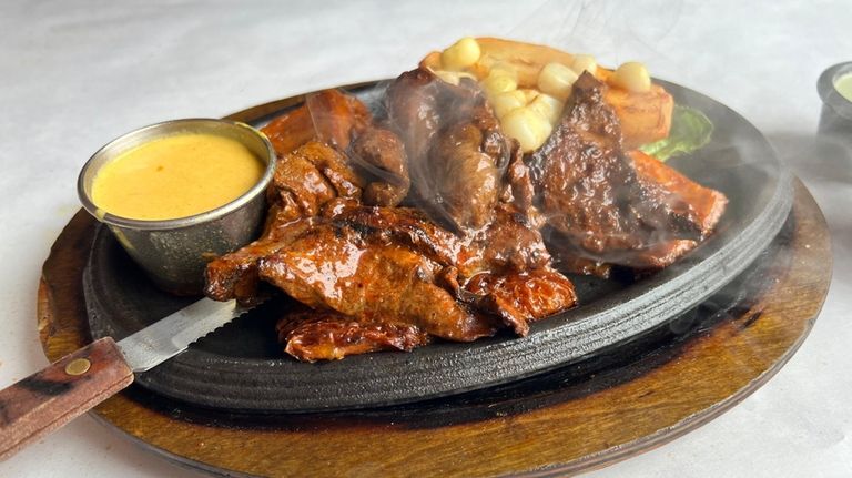 Anticuchos, or grilled beef hearts, a popular Peruvian street food,...