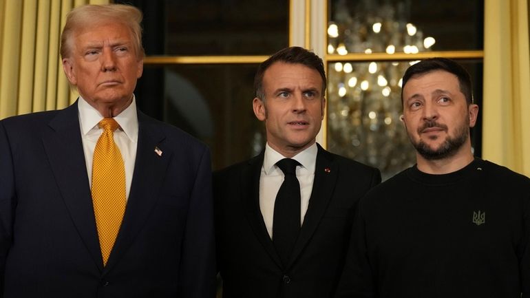 French President Emmanuel Macron, center, poses with President-elect Donald Trump,...