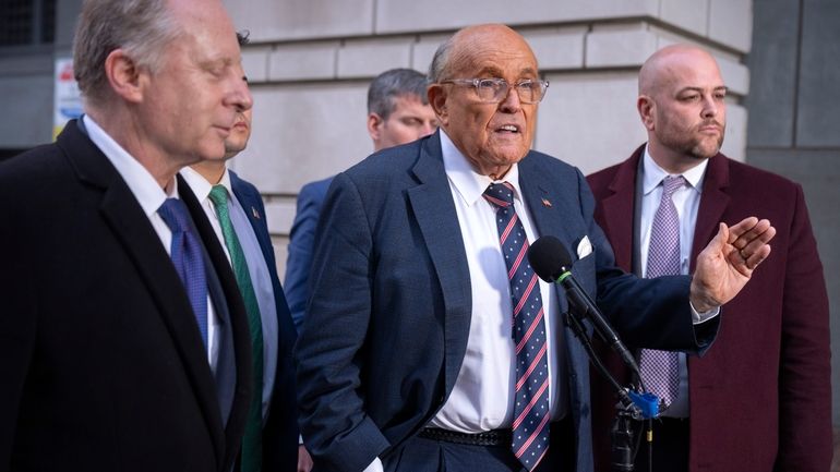 Rudy Giuliani, center, speaks to reporters after leaving federal court...