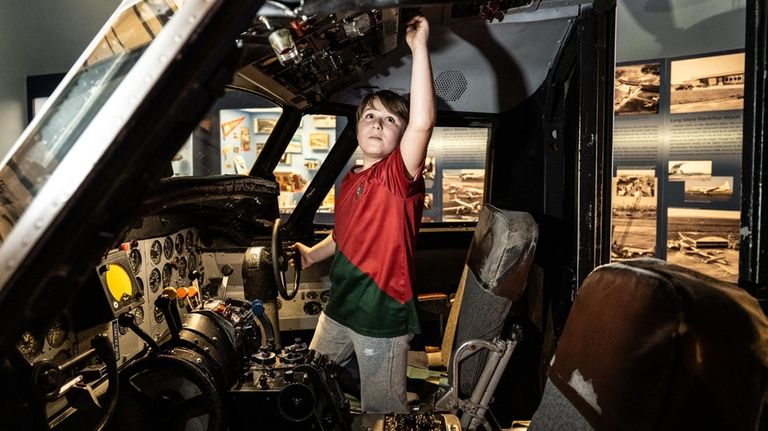 Shane Dreyzin, 9, explores the cockpit of a plane at...