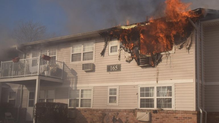 A fire rages Tuesday at a 32-unit Central Islip apartment complex...