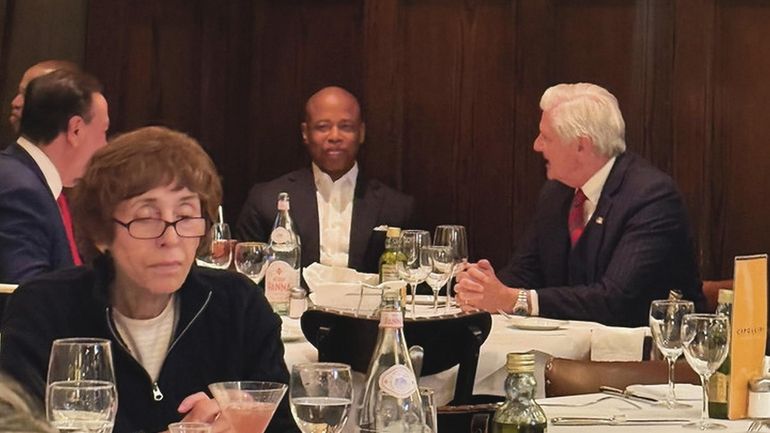 New York City Mayor Eric Adams, center, dines Tuesday night...