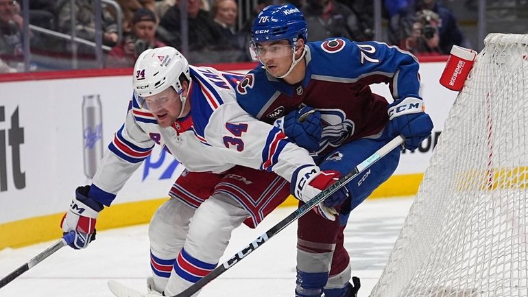 Rangers right wing Arthur Kaliyev, left, pursues the puck with...