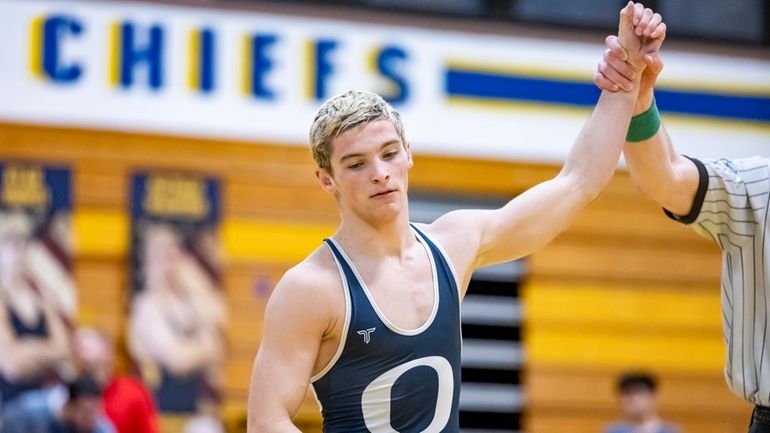 Oceanside’s Jake Strianese gets his hand raised after pinning Massapequa’s...