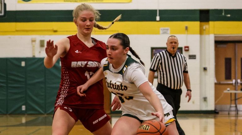 Julia Dank of Ward Melville drives past Kaitlyn Brewer of...