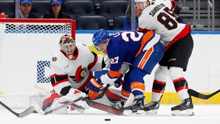 Leevi Merilainen and Jake Sanderson of the Ottawa Senatoirs defend the...