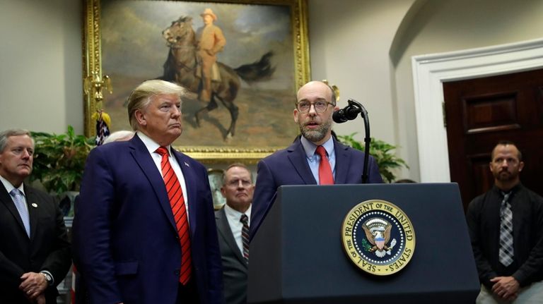 President-elect Donald Trump listens as his then-acting director of the...