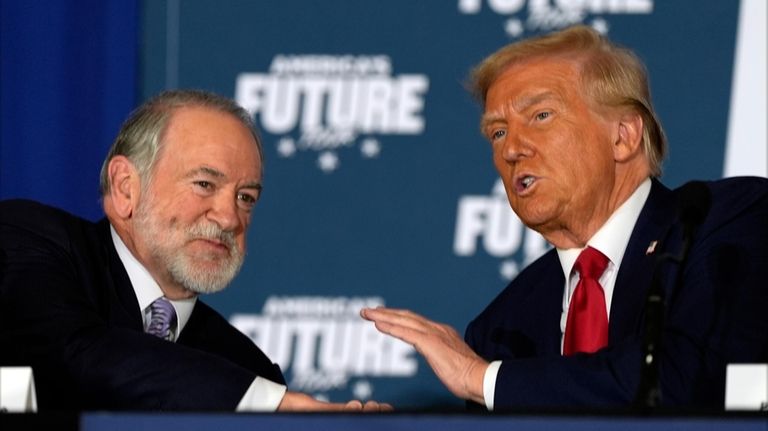 President-elect Donald Trump talks with former Arkansas Gov. Mike Huckabee during...